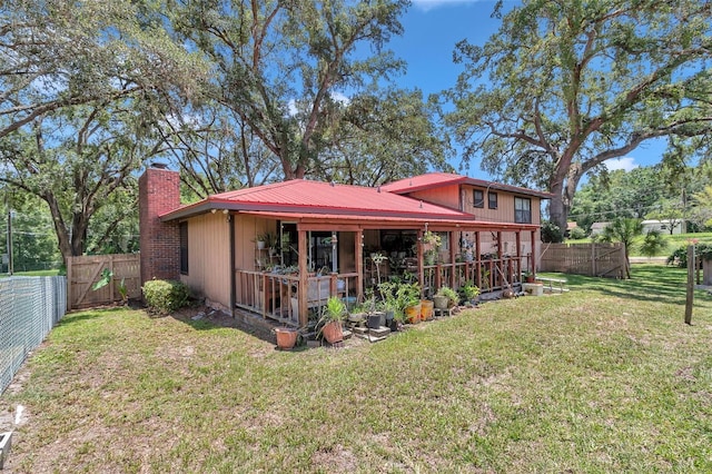 2676 SE 52nd Ave, Ocala, FL 34480 - rear view of house with a chimney, a fenced backyard, and a metal roof
