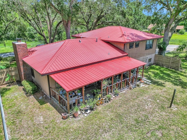 2676 SE 52nd Ave, Ocala, FL 34480 - back of house with a metal roof, view of wooded area, and a chimney