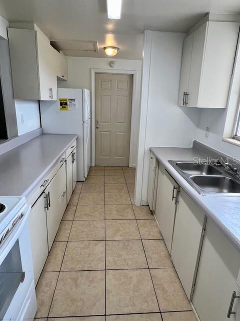 3801 SW 147th Lane Rd, Ocala, FL 34473 - kitchen featuring white cabinets, light tile patterned flooring, light countertops, and white stove