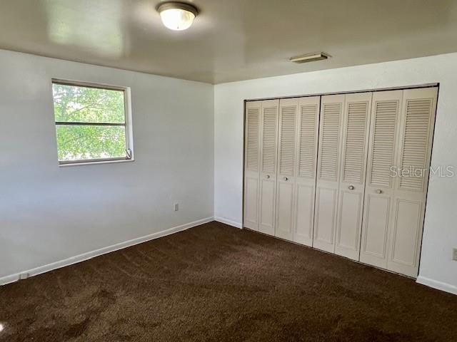 3801 SW 147th Lane Rd, Ocala, FL 34473 - unfurnished bedroom featuring dark carpet and a closet