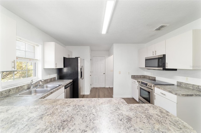 5596 NW 57th St, Ocala, FL 34482 - kitchen with stainless steel appliances, light wood-style flooring, light countertops, and white cabinets