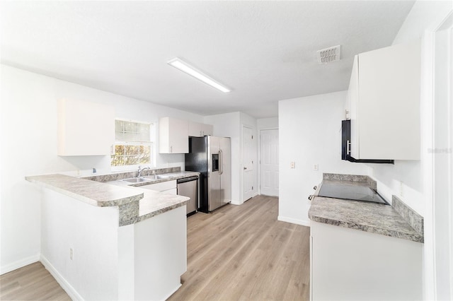 5596 NW 57th St, Ocala, FL 34482 - kitchen featuring stainless steel appliances, light wood-type flooring, light countertops, a peninsula, and white cabinets