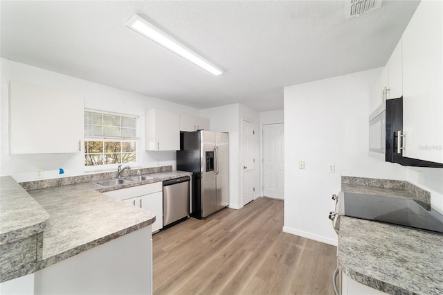 5596 NW 57th St, Ocala, FL 34482 - kitchen featuring stainless steel appliances, light wood-style floors, white cabinets, and light countertops