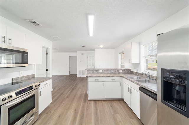 5596 NW 57th St, Ocala, FL 34482 - kitchen with stainless steel appliances, light wood-style floors, and white cabinets