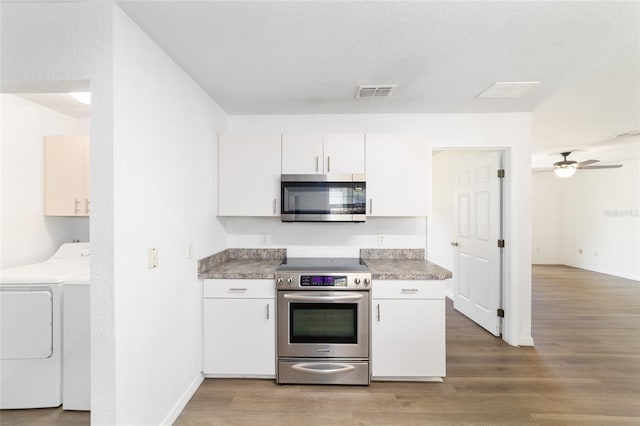 5596 NW 57th St, Ocala, FL 34482 - kitchen featuring appliances with stainless steel finishes, washing machine and clothes dryer, light wood-type flooring, and white cabinets