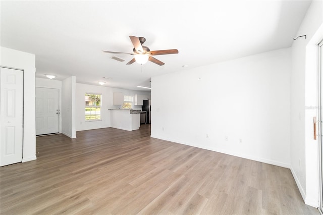 5596 NW 57th St, Ocala, FL 34482 - unfurnished living room with a ceiling fan and light wood-type flooring