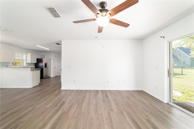 5596 NW 57th St, Ocala, FL 34482 - unfurnished living room featuring healthy amount of natural light, light wood-type flooring, and a ceiling fan