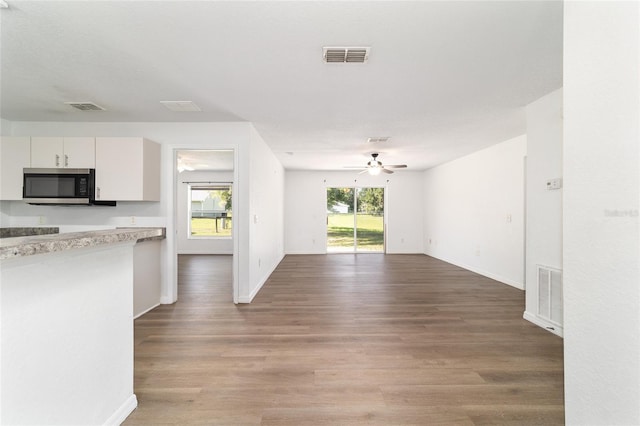 5596 NW 57th St, Ocala, FL 34482 - kitchen with stainless steel microwave, ceiling fan, light wood-style flooring, and light countertops