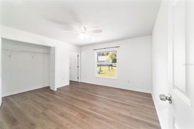 5596 NW 57th St, Ocala, FL 34482 - unfurnished bedroom featuring wood finished floors, a closet, a ceiling fan, and a textured ceiling