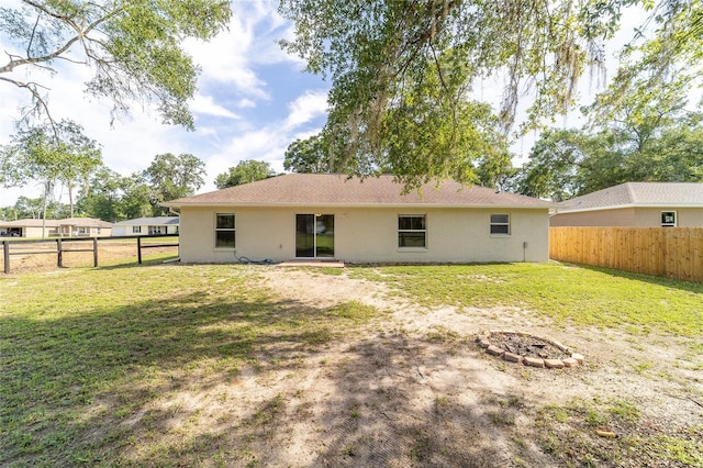 5596 NW 57th St, Ocala, FL 34482 - rear view of property featuring a fire pit, a fenced backyard, and stucco siding