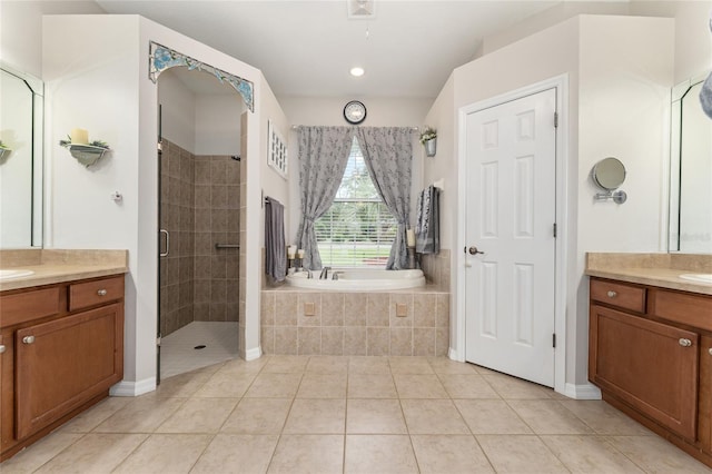 19115 SW 98th Loop, Dunnellon, FL 34432 - full bathroom featuring two vanities, a stall shower, a garden tub, and tile patterned flooring