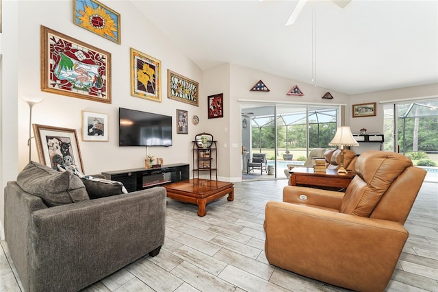 19115 SW 98th Loop, Dunnellon, FL 34432 - living area featuring wood tiled floors, a ceiling fan, a sunroom, and high vaulted ceiling