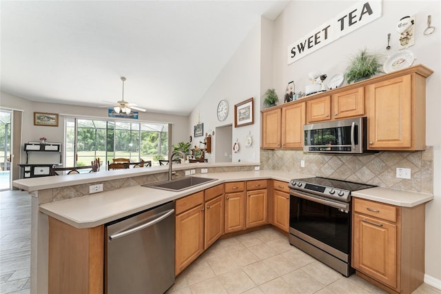 19115 SW 98th Loop, Dunnellon, FL 34432 - kitchen featuring appliances with stainless steel finishes, a peninsula, tasteful backsplash, light countertops, and vaulted ceiling