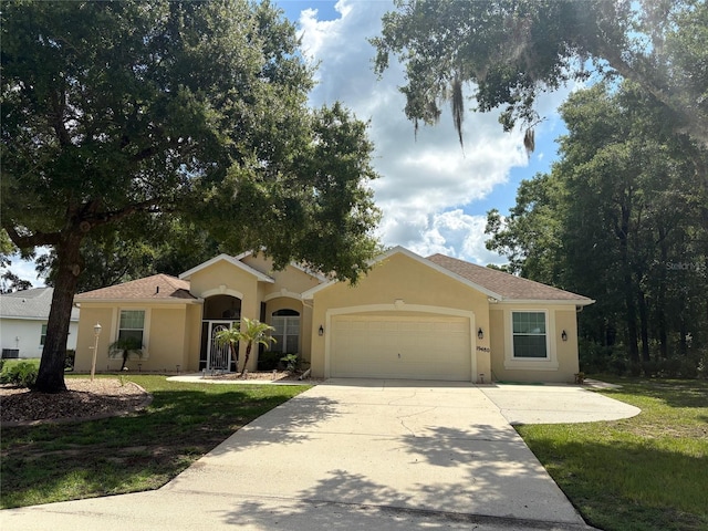 19480 SW 100th Loop, Dunnellon, FL 34432 - single story home with an attached garage, concrete driveway, stucco siding, and a front yard