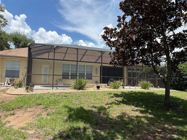 19480 SW 100th Loop, Dunnellon, FL 34432 - rear view of house featuring a lawn, a lanai, and stucco siding