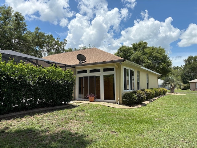 19480 SW 100th Loop, Dunnellon, FL 34432 - back of house with a yard, stucco siding, and a shingled roof