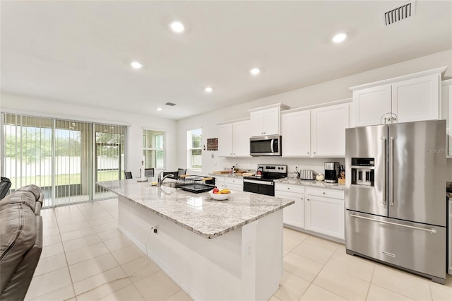 6175 SW 88th Loop, Ocala, FL 34476 - kitchen with appliances with stainless steel finishes, open floor plan, white cabinetry, light stone countertops, and a center island with sink