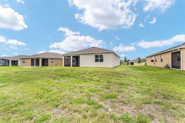 6175 SW 88th Loop, Ocala, FL 34476 - back of house with a sunroom, a lawn, and stucco siding