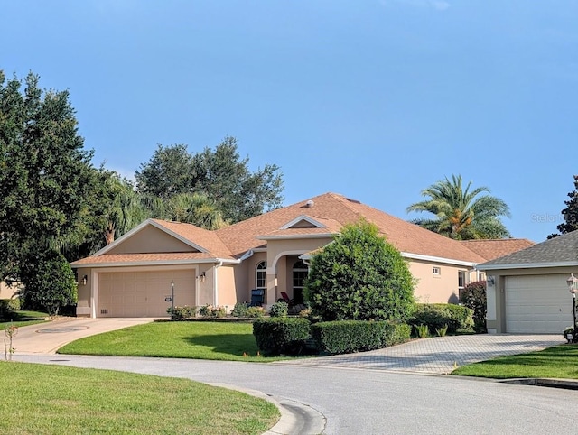 2721 Day Lily Run, The Villages, FL 32162 - view of front facade featuring concrete driveway, stucco siding, a front yard, and an attached garage