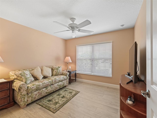 2721 Day Lily Run, The Villages, FL 32162 - living area featuring a ceiling fan, light wood-type flooring, and a textured ceiling