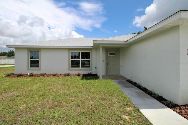 9 Hemlock Terrace Ln, Ocala, FL 34472 - doorway to property with a lawn, stucco siding, and a shingled roof