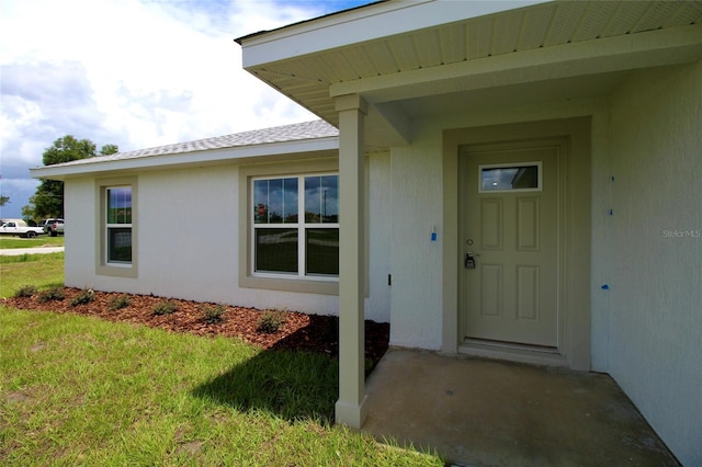 9 Hemlock Terrace Ln, Ocala, FL 34472 - doorway to property with a yard and stucco siding