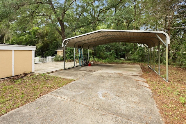 581 NE 44th Ave, Ocala, FL 34470 - view of parking / parking lot featuring a carport, driveway, and view of wooded area