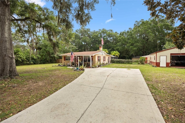 581 NE 44th Ave, Ocala, FL 34470 - view of front of house featuring a front lawn, driveway, view of wooded area, and an outdoor structure