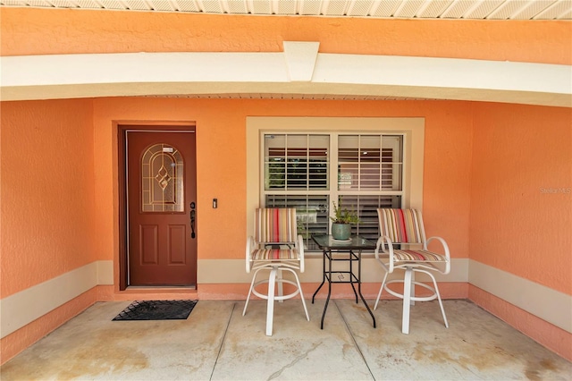3453 SE 147th Ln, Summerfield, FL 34491 - view of exterior entry with stucco siding and a porch