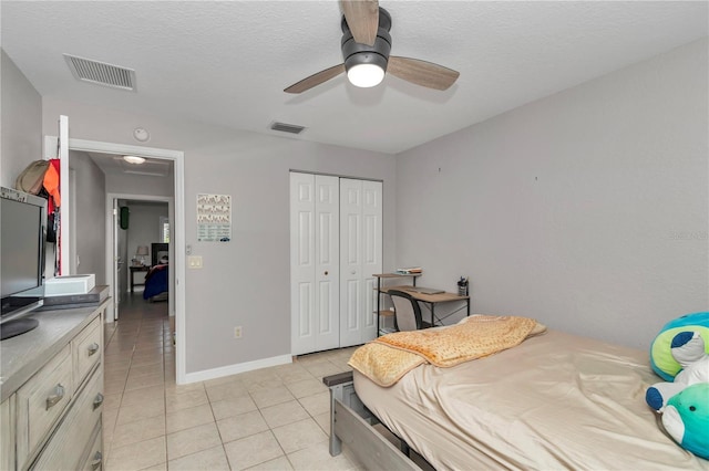 3453 SE 147th Ln, Summerfield, FL 34491 - bedroom with light tile patterned floors, a closet, a textured ceiling, and ceiling fan