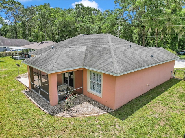 3453 SE 147th Ln, Summerfield, FL 34491 - back of house featuring a sunroom, a yard, stucco siding, and a shingled roof