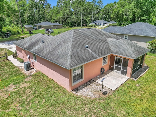 3453 SE 147th Ln, Summerfield, FL 34491 - back of house featuring a sunroom, roof with shingles, stucco siding, and a yard
