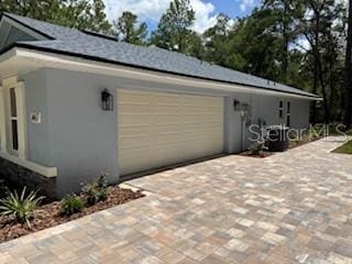 1467 E Odin Dr, Citrus Springs, FL 34434 - view of property exterior with an attached garage, decorative driveway, and stucco siding