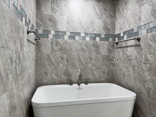 1467 E Odin Dr, Citrus Springs, FL 34434 - bathroom with a soaking tub and tile walls