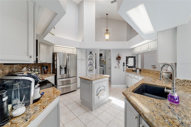 3629 SE 54th Ave, Ocala, FL 34480 - kitchen with stainless steel fridge with ice dispenser, light tile patterned floors, light stone counters, high vaulted ceiling, and decorative backsplash