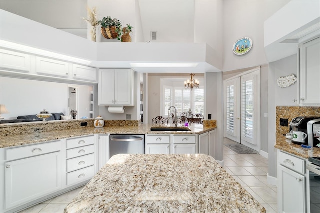 3629 SE 54th Ave, Ocala, FL 34480 - kitchen featuring a high ceiling, stainless steel dishwasher, a chandelier, light tile patterned flooring, and white cabinetry