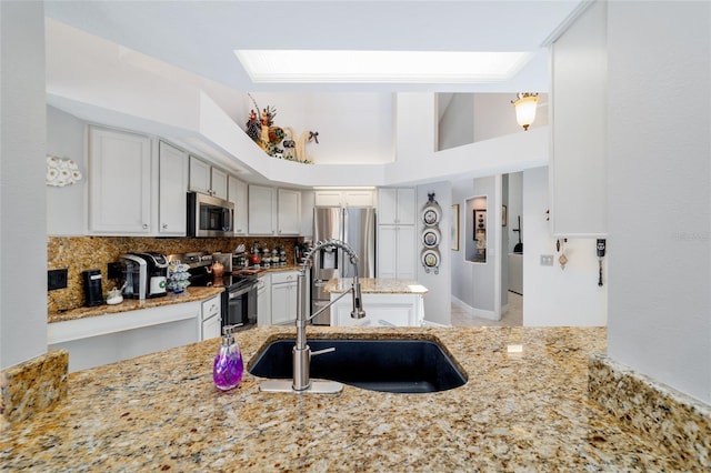 3629 SE 54th Ave, Ocala, FL 34480 - kitchen with stainless steel appliances, light stone countertops, tasteful backsplash, and white cabinets