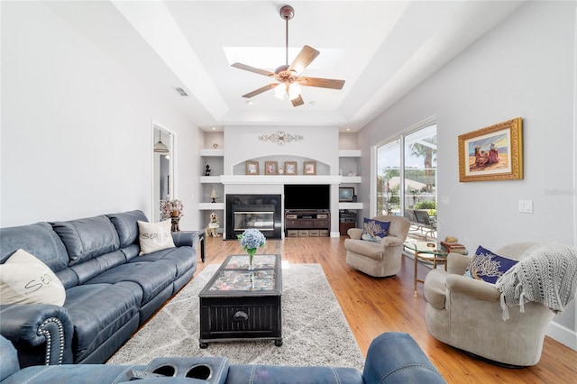 3629 SE 54th Ave, Ocala, FL 34480 - living area with built in shelves, wood finished floors, a raised ceiling, a ceiling fan, and a skylight