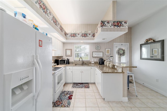 3629 SE 54th Ave, Ocala, FL 34480 - kitchen with white appliances, a peninsula, light tile patterned flooring, and light stone counters