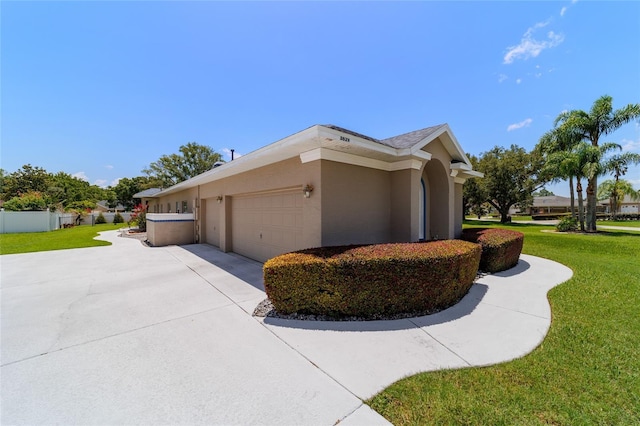 3629 SE 54th Ave, Ocala, FL 34480 - view of side of home featuring concrete driveway, a lawn, a garage, and stucco siding