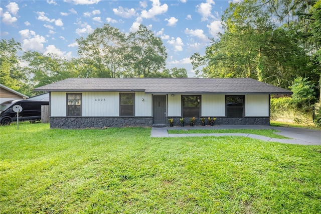 6021 NW 54th Ter, Ocala, FL 34482 - view of front facade with stone siding, a front lawn, and a shingled roof