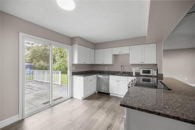 6021 NW 54th Ter, Ocala, FL 34482 - kitchen featuring stainless steel dishwasher, white microwave, stove, light wood finished floors, and white cabinets