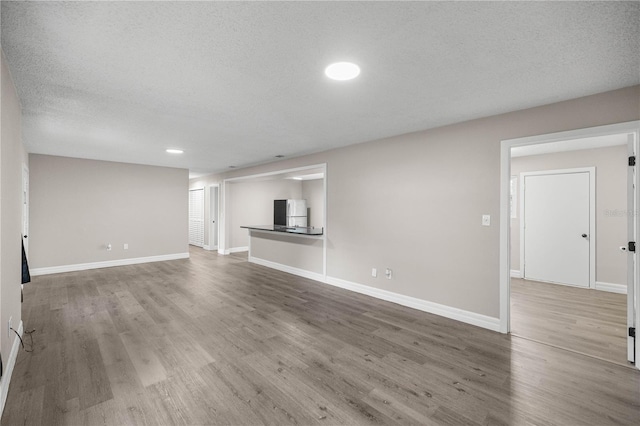 6021 NW 54th Ter, Ocala, FL 34482 - unfurnished living room featuring wood finished floors and a textured ceiling