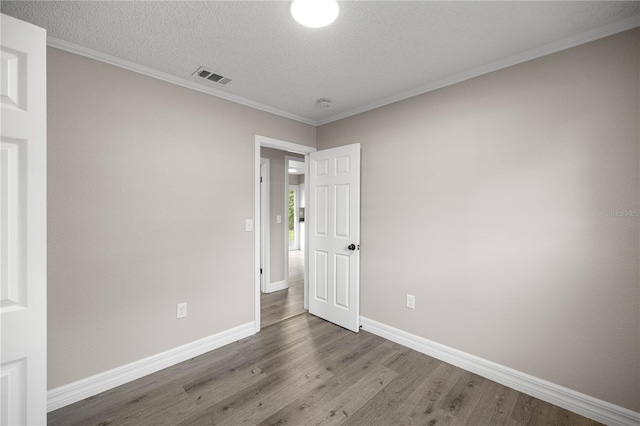 6021 NW 54th Ter, Ocala, FL 34482 - unfurnished room with wood finished floors, ornamental molding, a textured ceiling, and a smoke detector