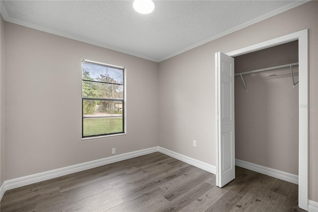 6021 NW 54th Ter, Ocala, FL 34482 - unfurnished bedroom with wood finished floors, a closet, crown molding, and a textured ceiling