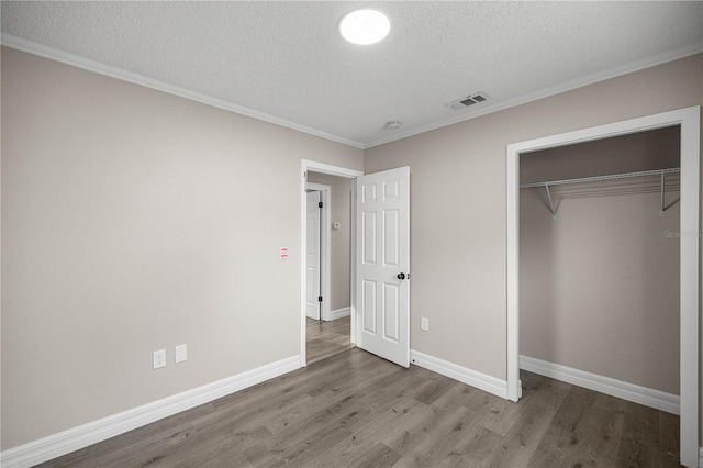 6021 NW 54th Ter, Ocala, FL 34482 - unfurnished bedroom with a textured ceiling, wood finished floors, crown molding, and a closet