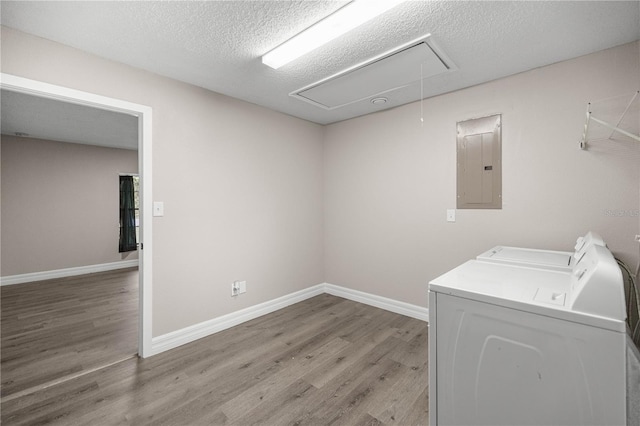 6021 NW 54th Ter, Ocala, FL 34482 - laundry room with electric panel, attic access, washing machine and clothes dryer, wood finished floors, and a textured ceiling