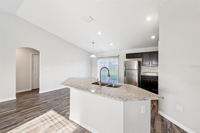 146 Juniper Loop Cir, Ocala, FL 34480 - kitchen featuring freestanding refrigerator, dark wood-style floors, arched walkways, a kitchen island with sink, and dark brown cabinets