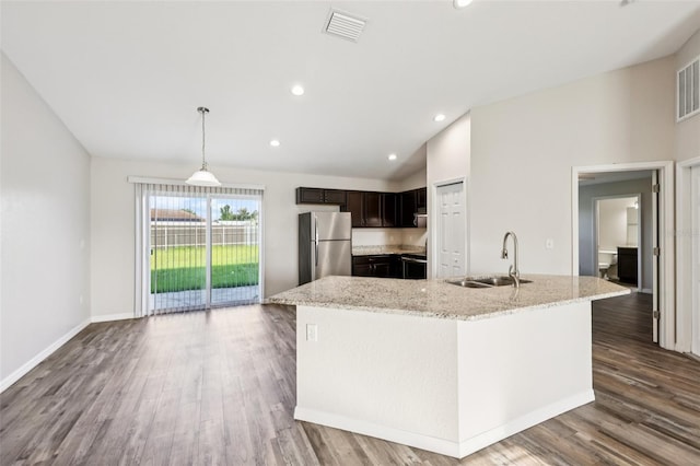146 Juniper Loop Cir, Ocala, FL 34480 - kitchen with freestanding refrigerator, vaulted ceiling, wood finished floors, light stone countertops, and recessed lighting