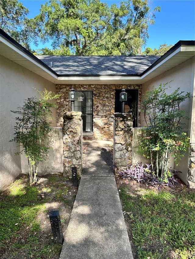2070 SE 50th Ter, Ocala, FL 34480 - property entrance with stucco siding, stone siding, and roof with shingles